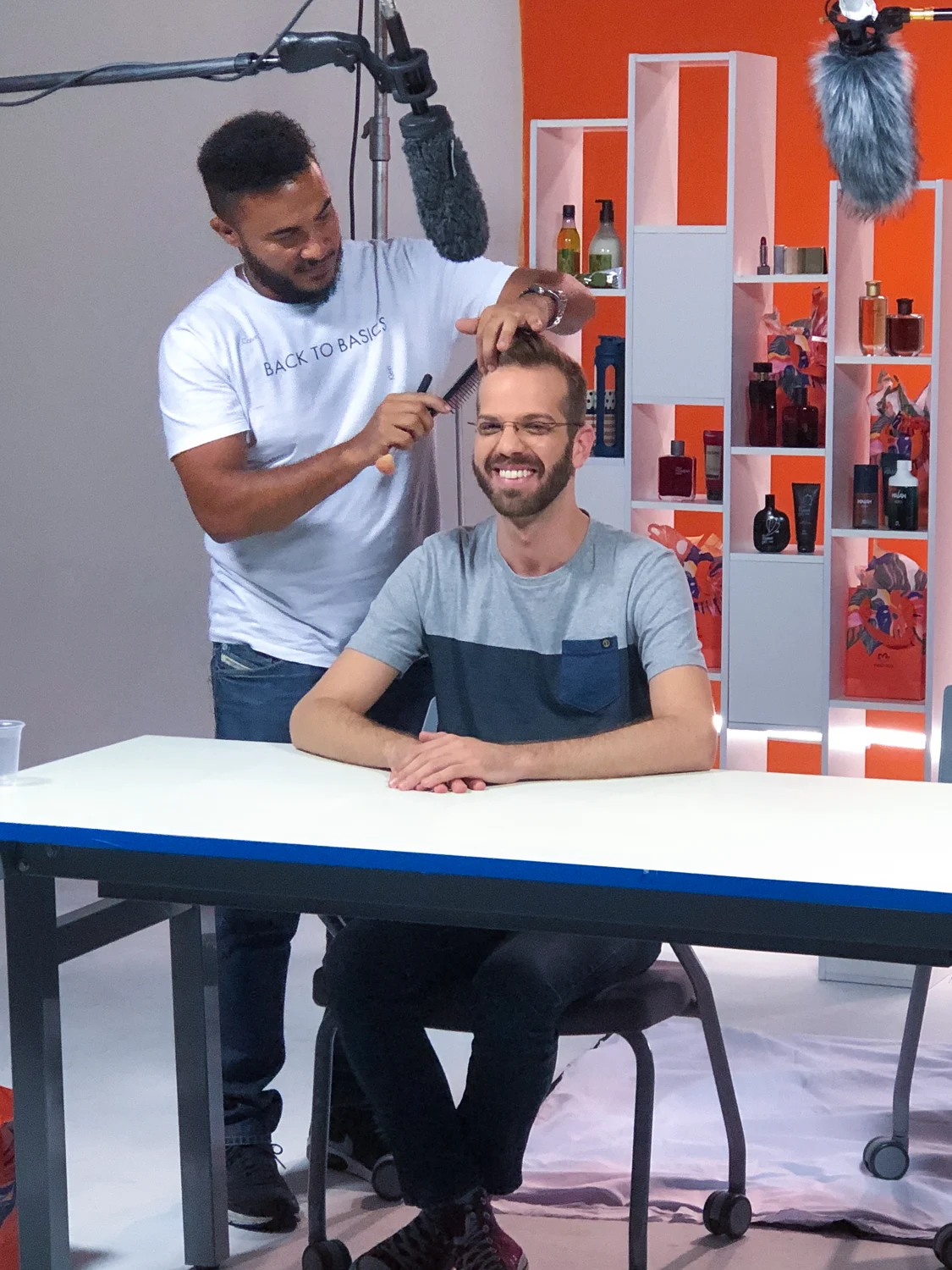 Apresentadores em gravação no estúdio laranja