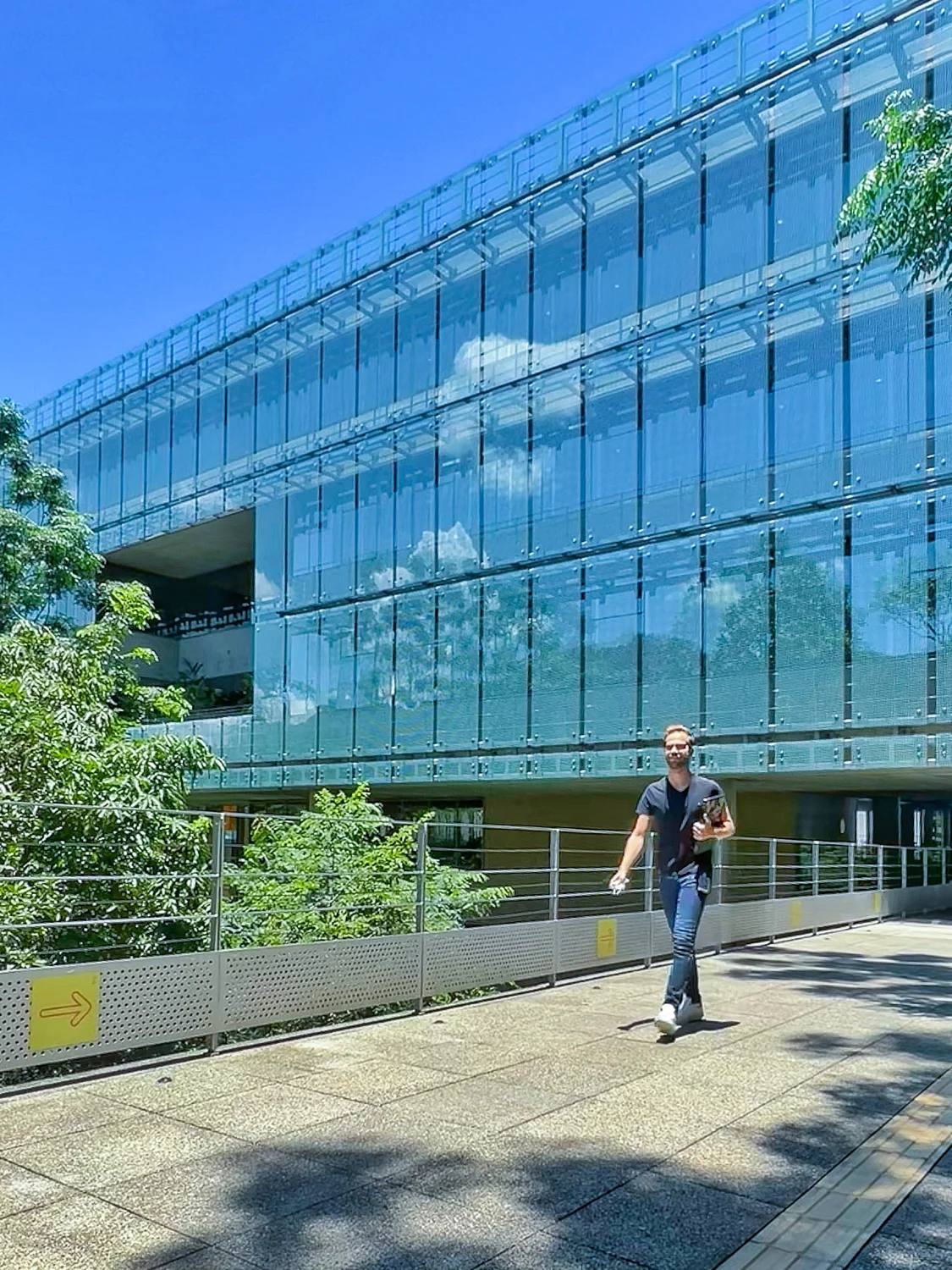 Pessoa diante de edifício corporativo envidraçado