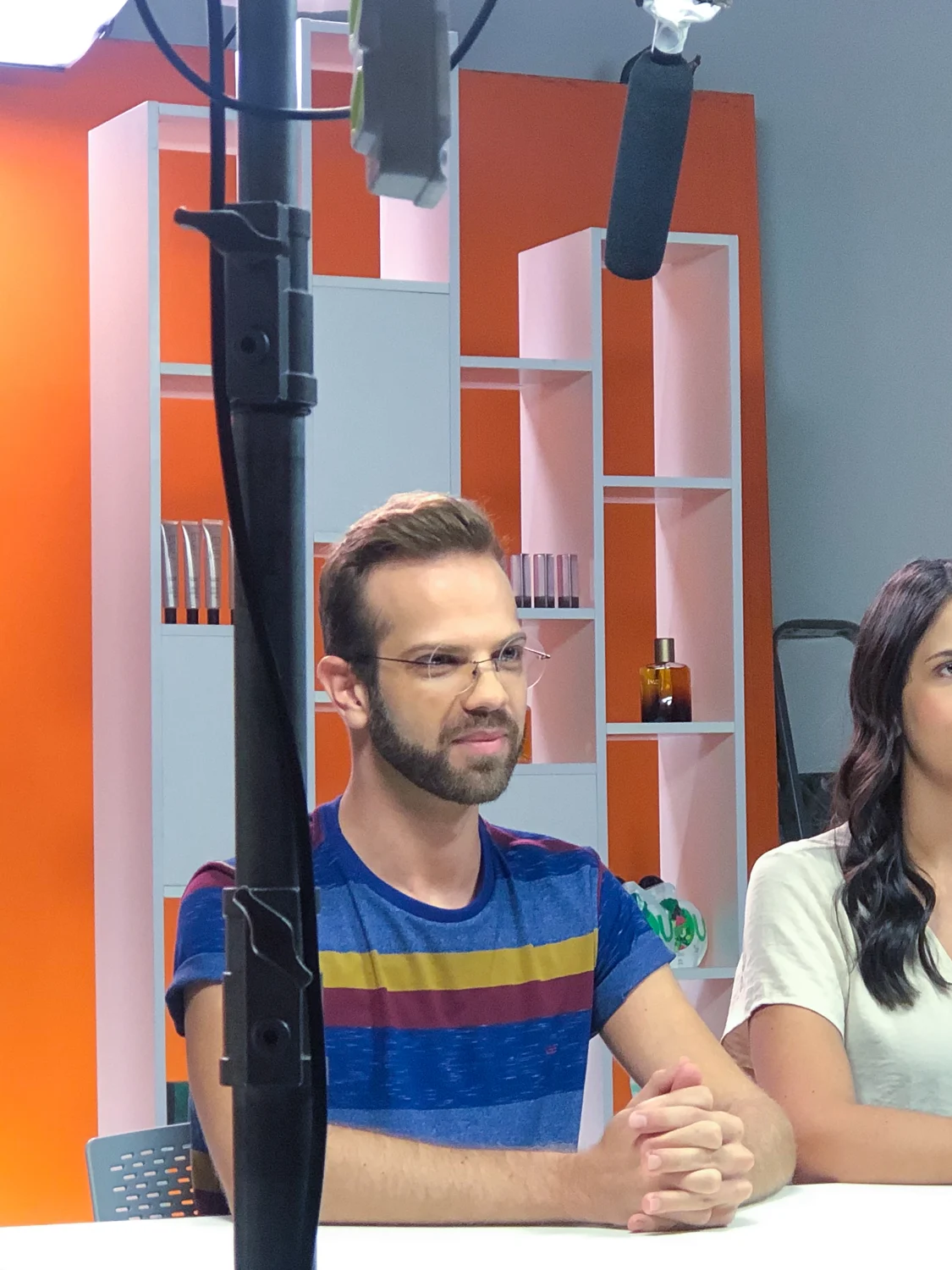 Apresentador diante de cenário laranja